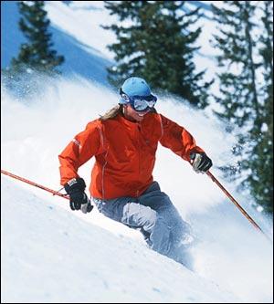A skier raises powder as she skis down a Utah mountain slope.